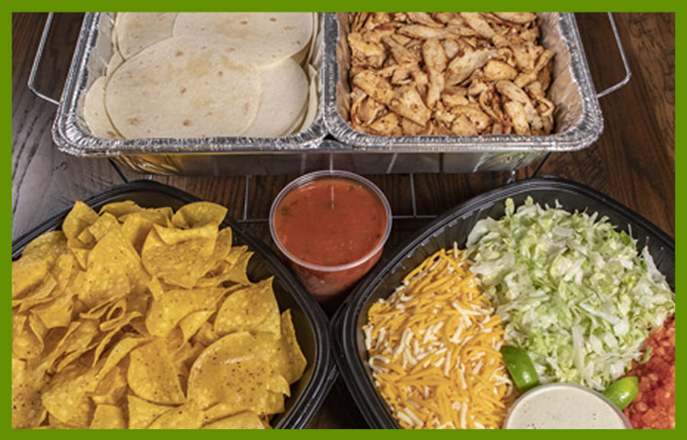 Chicken fajita fixings in catering dishes.