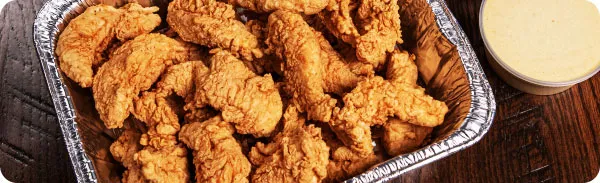 A chafing dish full of hand-breaded chicken tenders