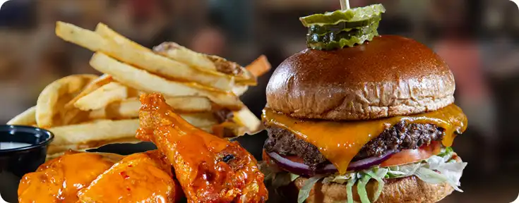 A cheeseburger, wings and french fries